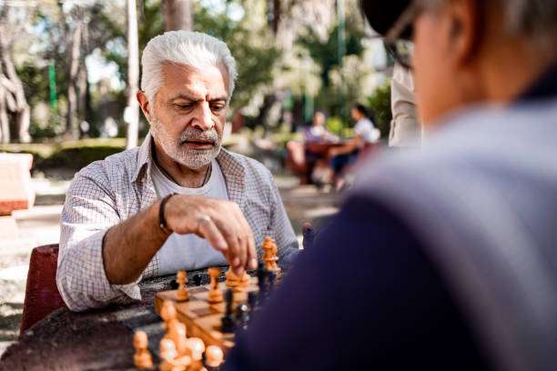 Man contemplating his move on a chess board.