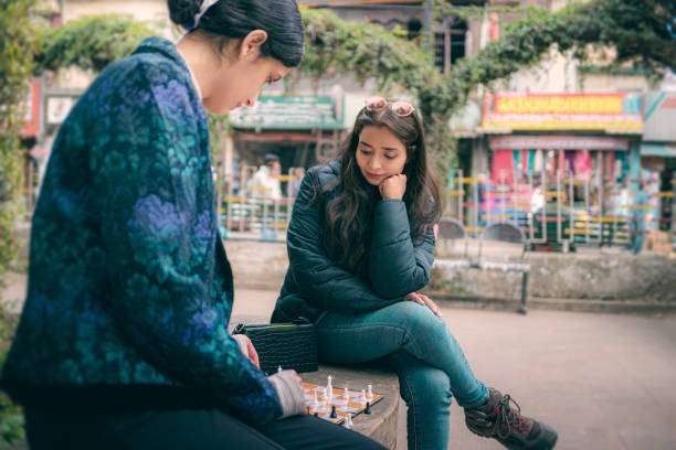 Two child girls playing chess together on a chess board.