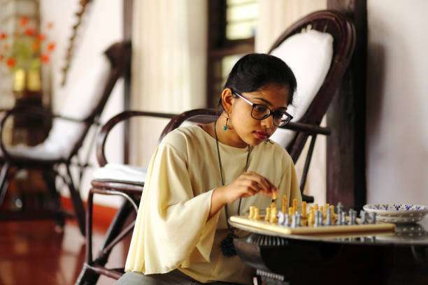 Young woman studying a chessboard strategy intensely
