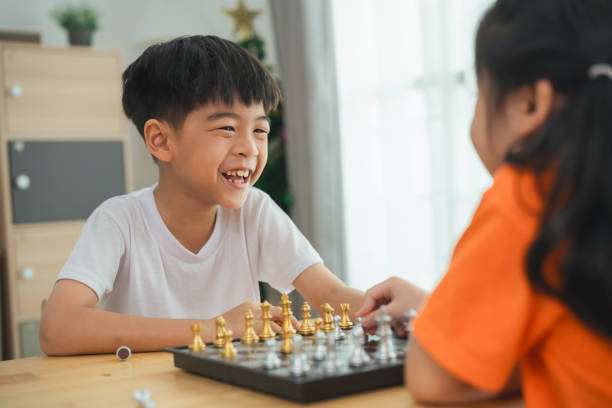 Children happily playing chess on a chessboard