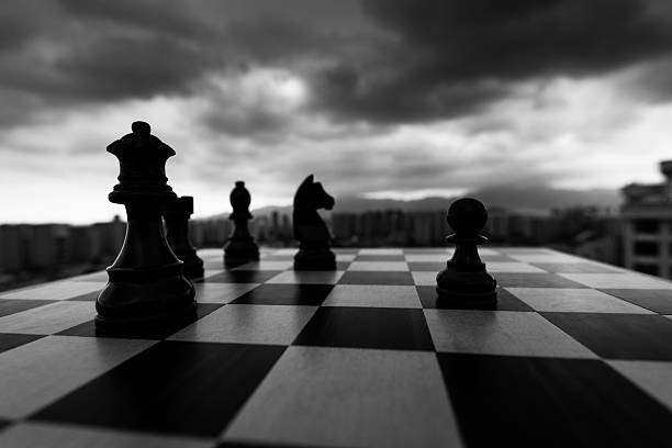 Dramatic black and white chess board setup against city skyline.