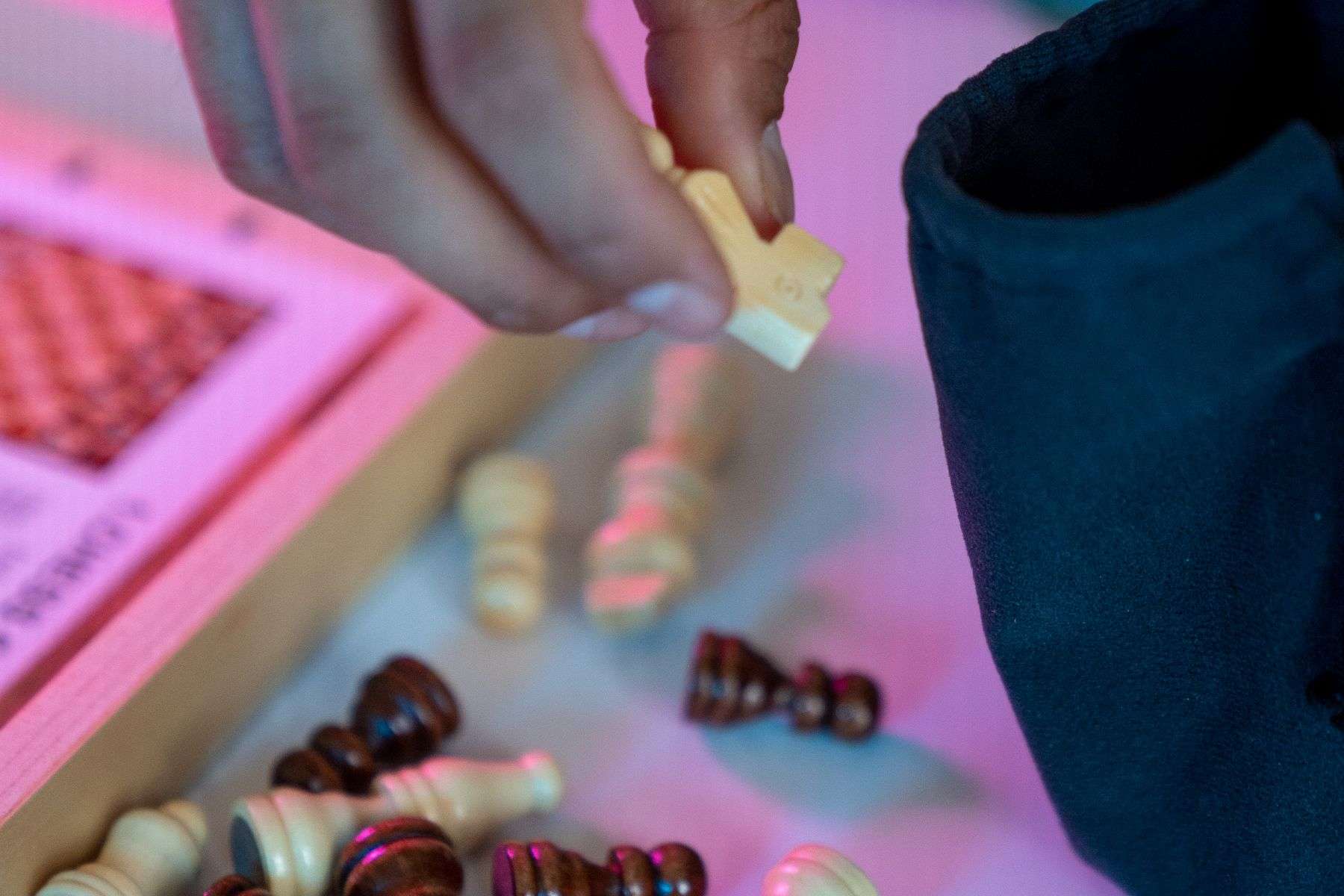 Hand placing a chess piece while checking the board position