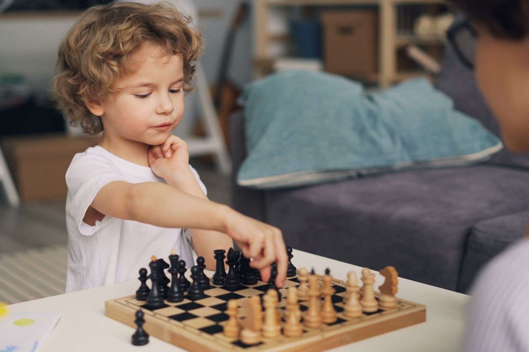 Young child concentrating on a beginner chess game