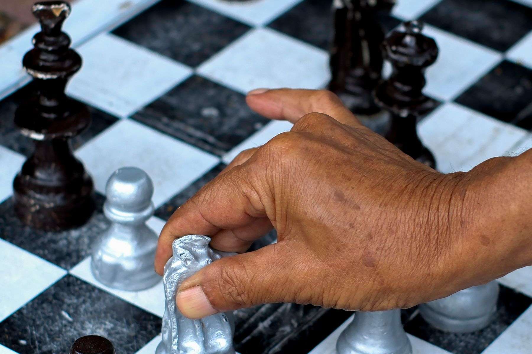 Hand lifting a chess piece during a stability and handling check