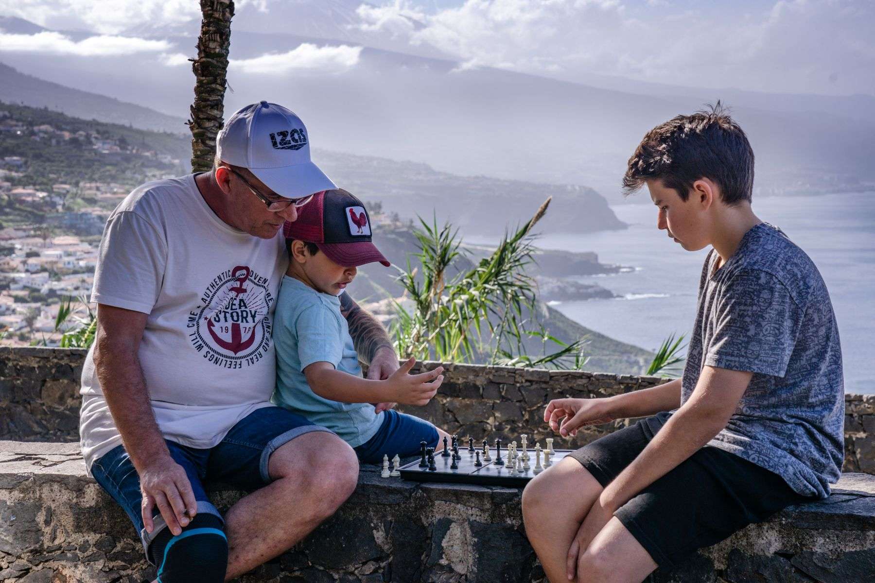 Family playing chess outdoors while travelling